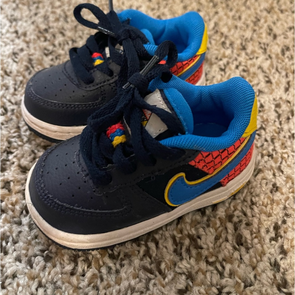 Nike infant shoes size 4C with blue swoosh and yellow trim, and red and black.